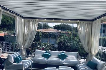 Pergola bioclimatica Med Twist Gibus con tendaggi decorativi